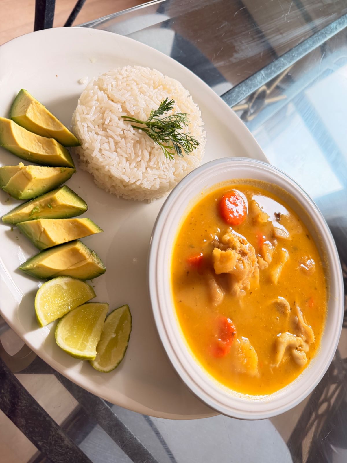 Sopa casera acompañada de arroz blanco, aguacate y limón